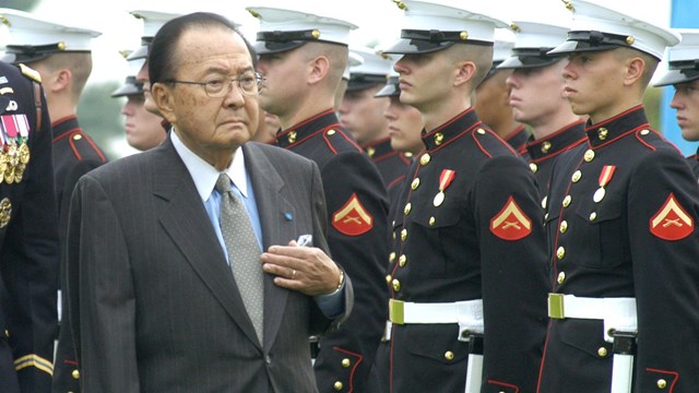 Daniel Inouye walks in front of crowd of marines