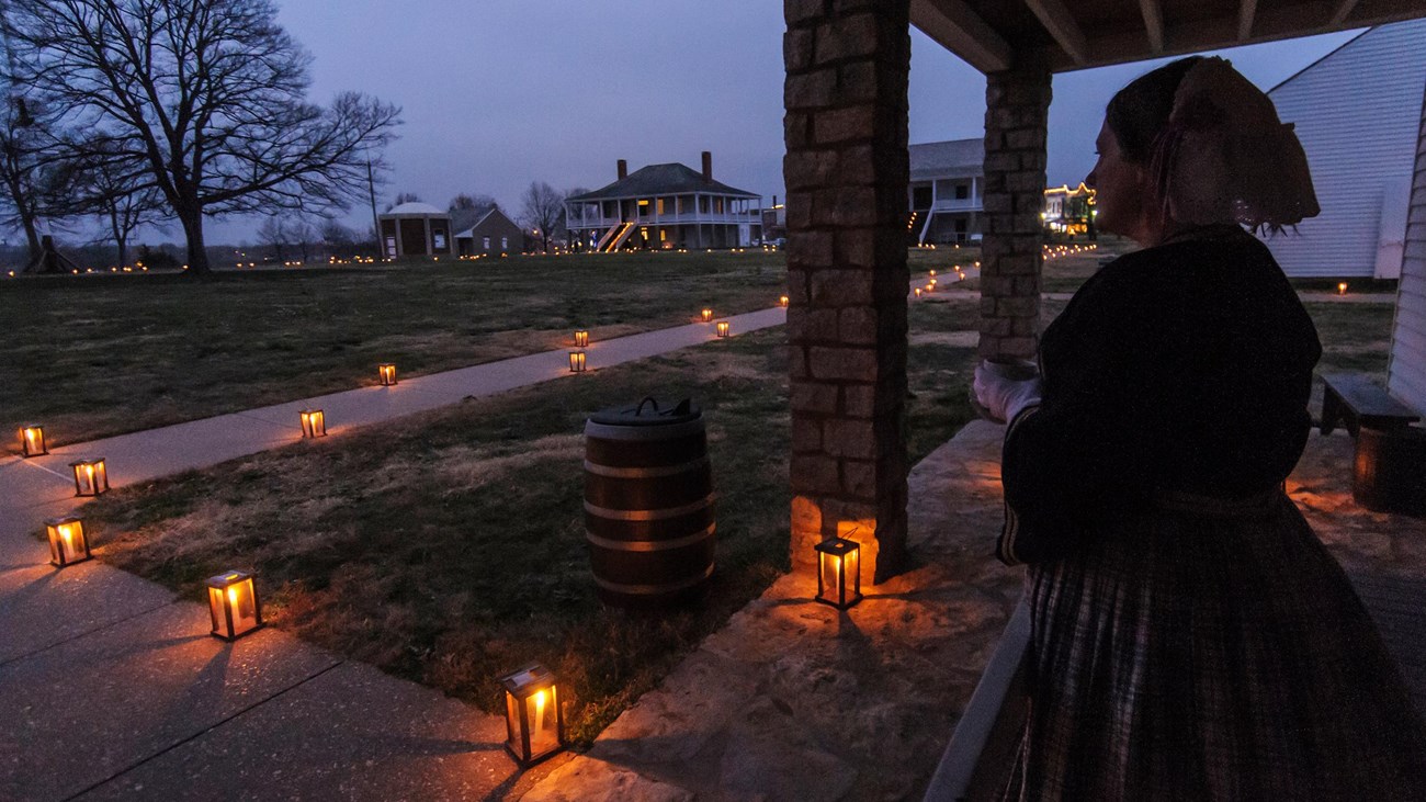 woman stands on porch overlooking fort