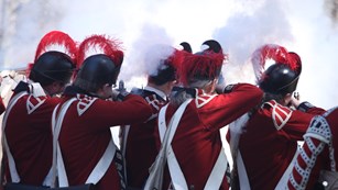 British reenactors fire a volley during the Battle Road tactical demonstration.