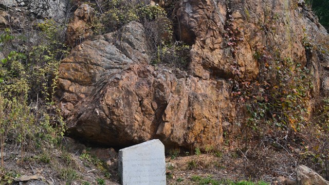 A red rock outcrop behind a small stone monument.