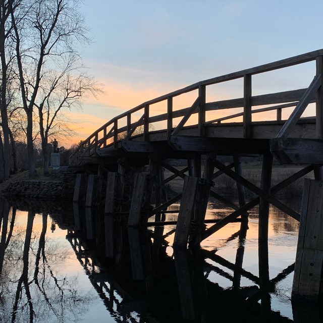 North Bridge timbers silhouetted against the sunset reflecting in the water.