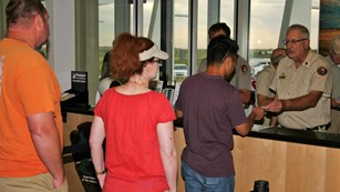 Visitors wait to be served by a park volunteer at an informaiton desk