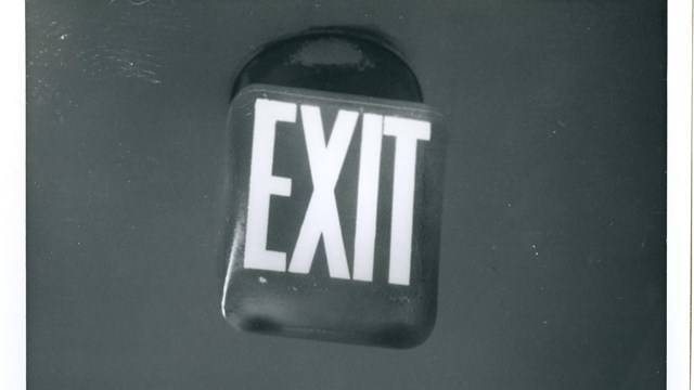 Black and white photo of a 1960s exit sign