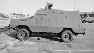 A heavy armored vehicle in a parking lot.