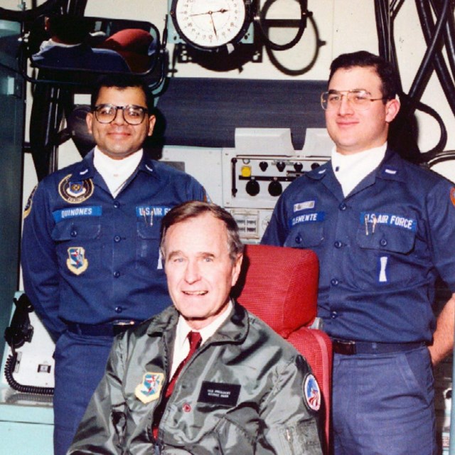 George HW Bush in a missile control facility with two missile crew members
