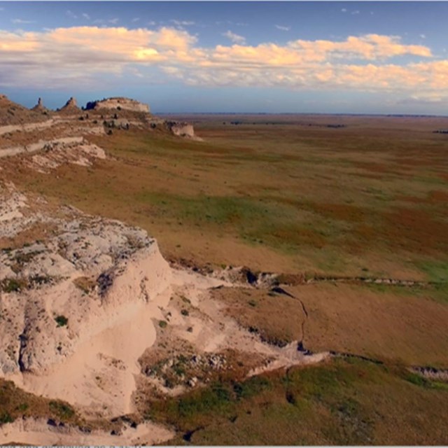 Aerial view of a vast prairie from above a tall butte