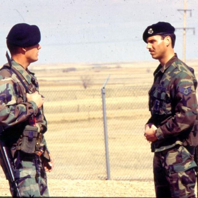 Two missile security policemen standing beside a fence