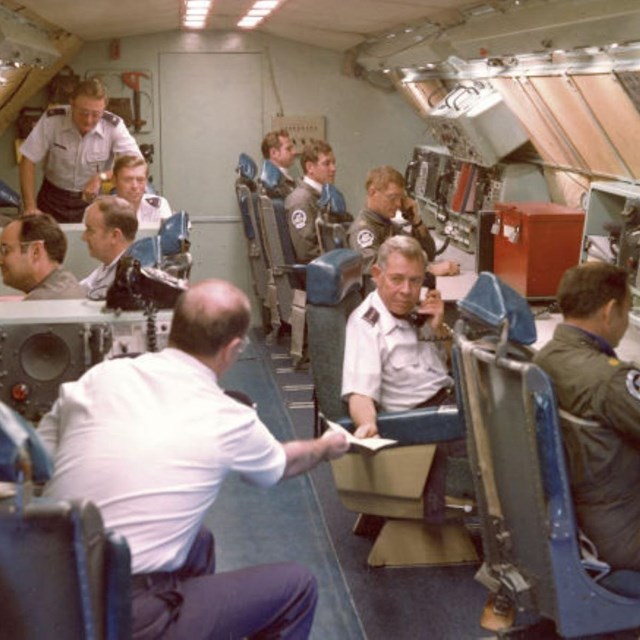 Air Force officers in long room sitting at desks