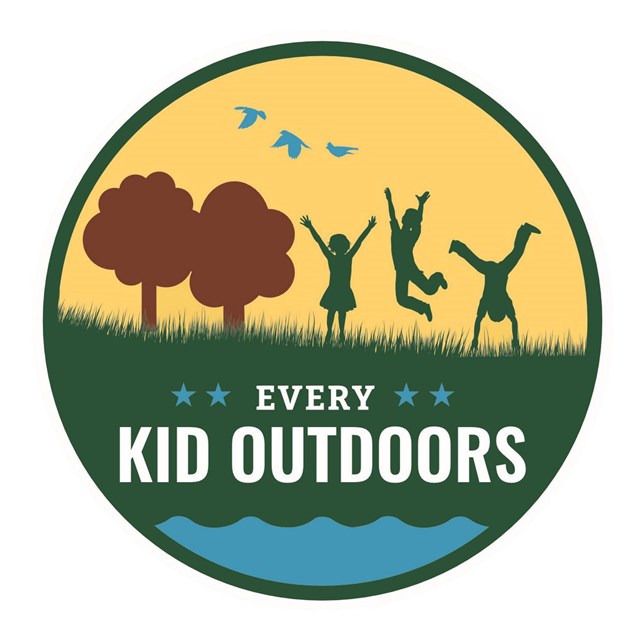 A circle with green grass and kids playing on a yellow background.