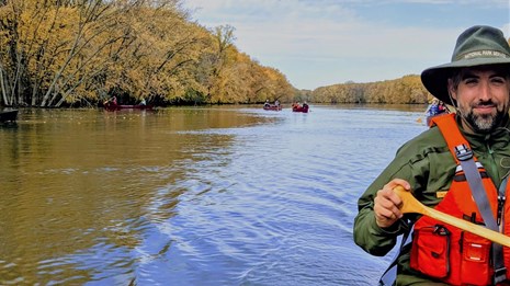 Two paddlers float down the river in their canoe.