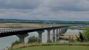 Chief Standing Bear bridge overlooking the Missouri River with cloudy skies. 
