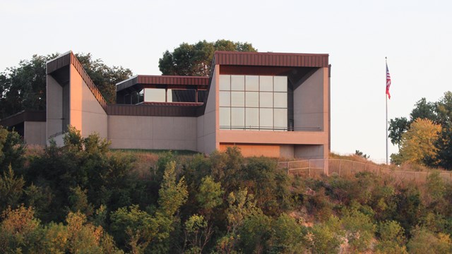 a building with large windows situated up on a hill