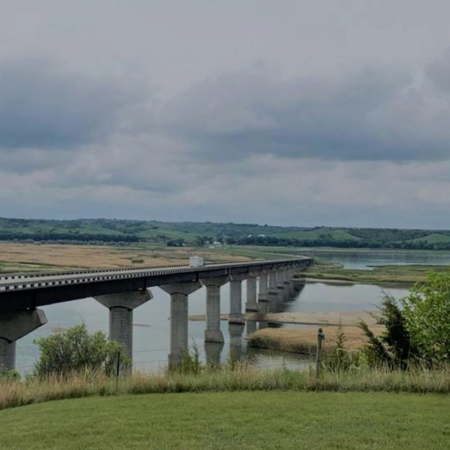 Chief Standing Bear bridge overlooking the Missouri River with cloudy skies. 