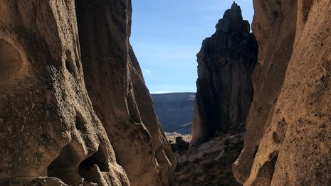 A hiking sign at the Rings Trail next to the potted cliffs at Hole-in-the-Wall