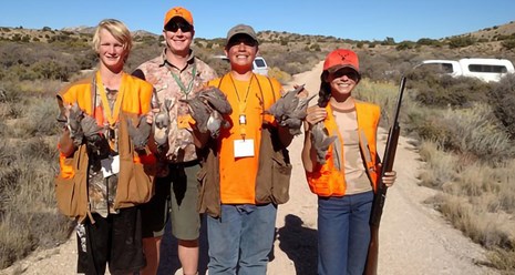 4 youth in orange vests display they quail catch