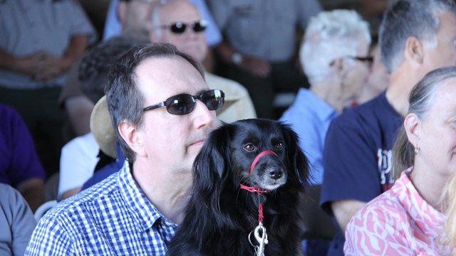 Man with black dog sitting on his lap in the Best Barn