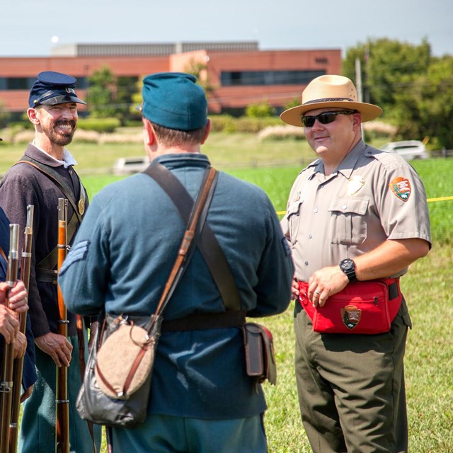 A park ranger talks with a group in Civil War period uniforms.
