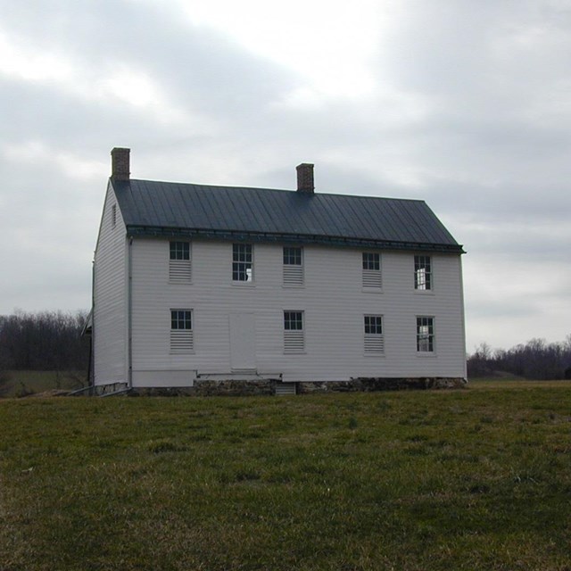 Two-story, white wooden farm house.