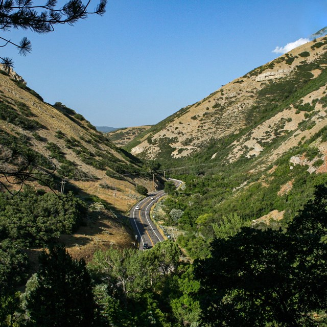 A large narrow valley with green grassy hills.