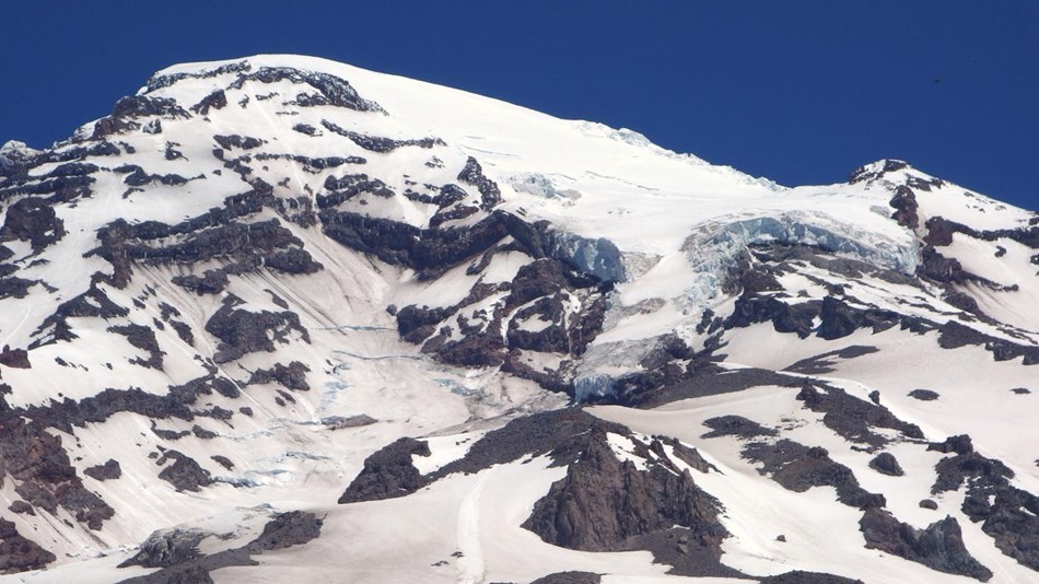 A glacier curves over the summit of Mount Rainier