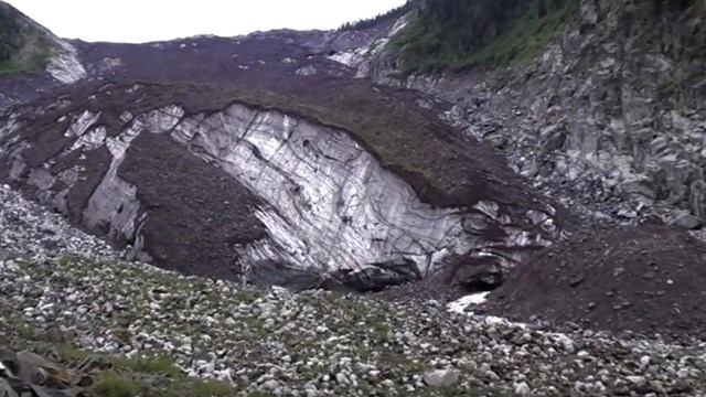 A rock-covered glacier in a narrow valley.