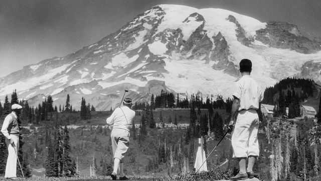 Men golfing with Mount Rainier in the background