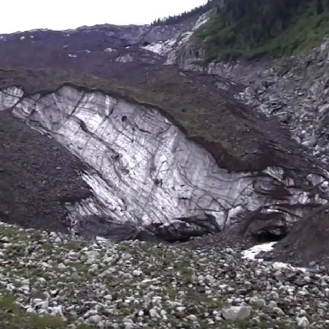 A rock-covered glacier in a narrow valley.