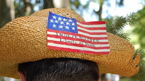 An American flag pinned to the back of a straw hat