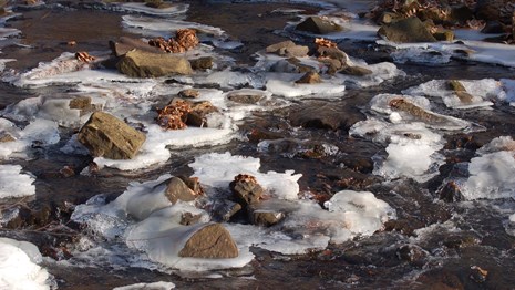A partially thawed stream with rocks