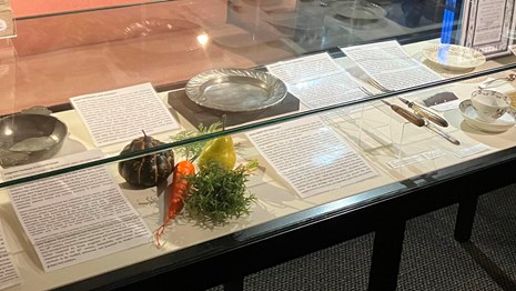 A museum case displaying artifacts relating to food, with descriptions and text beside each.