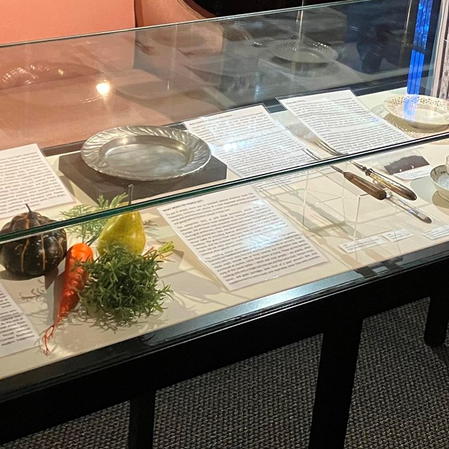 A museum case displaying artifacts relating to food, with descriptions and text beside each.