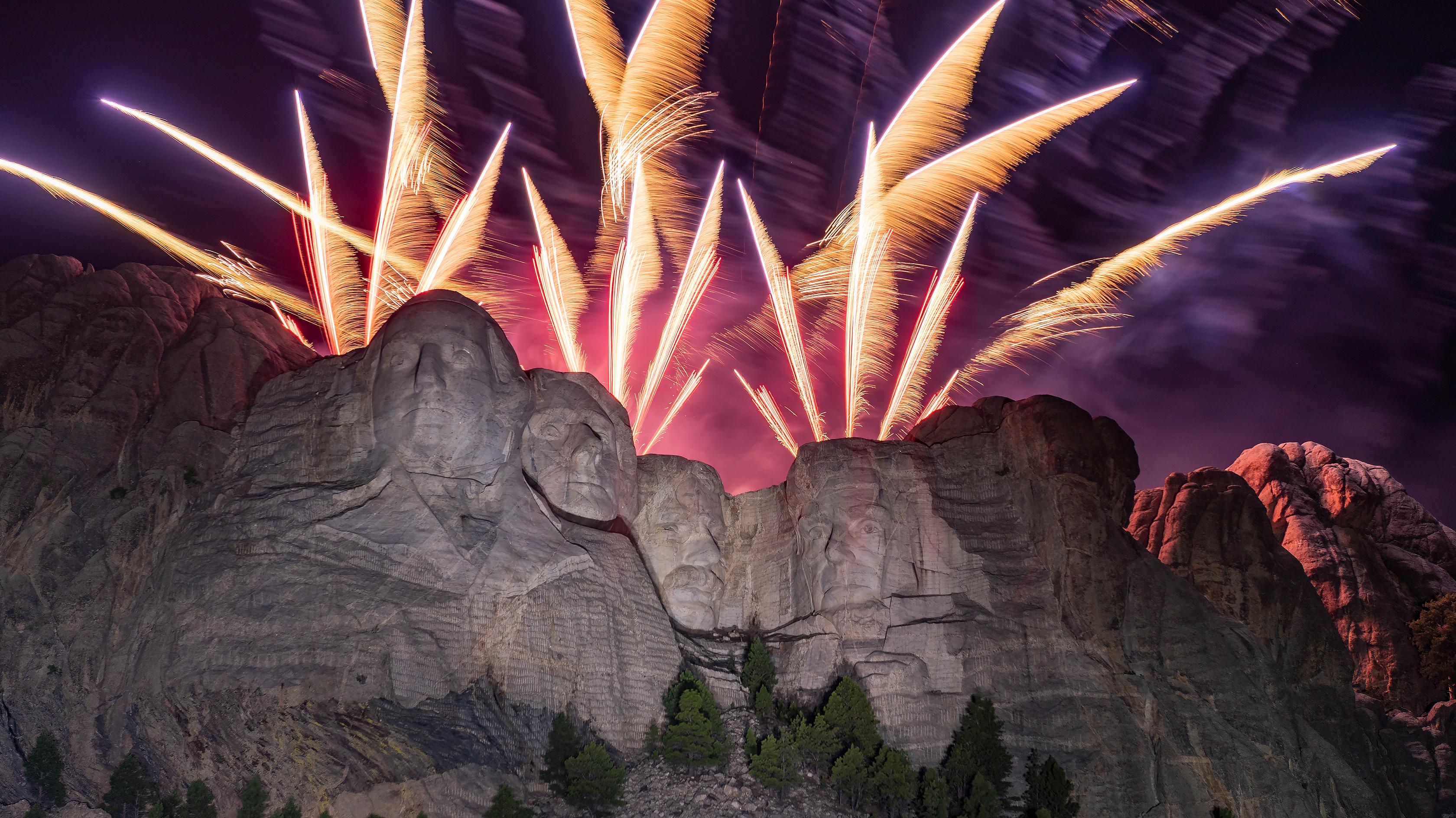 Fireworks display over the faces on Mount Rushmore at night.