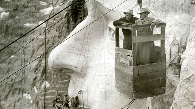 Gutzon Borglum and Lincoln Borglum in the tram car in front of the Jefferson face.