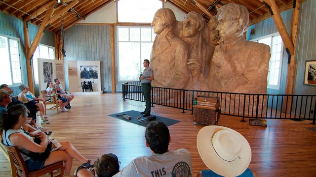 A park ranger describes the carving process inside the Sculptor's Studio.