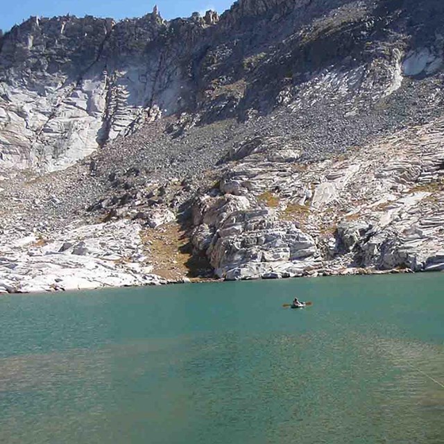 A researcher in an inflatable boat in a large lake.