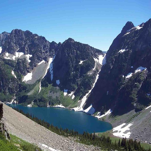 A mountain with remnant glaciers and glacial lake.