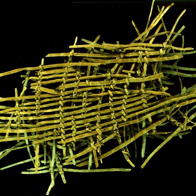 Yellowish reed fragments in a very loose weave