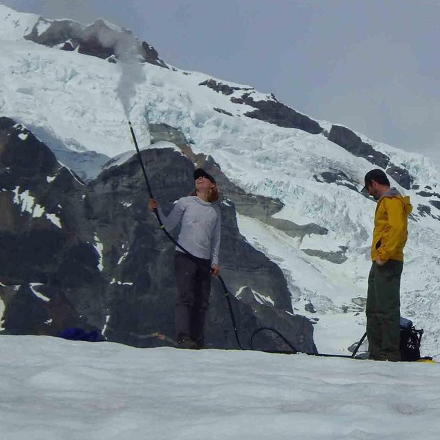 Researchers measure mass balance of a glacier.