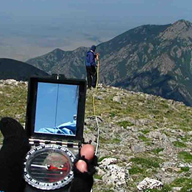 Researchers use a compass to lay out a vegetation monitoring transect.