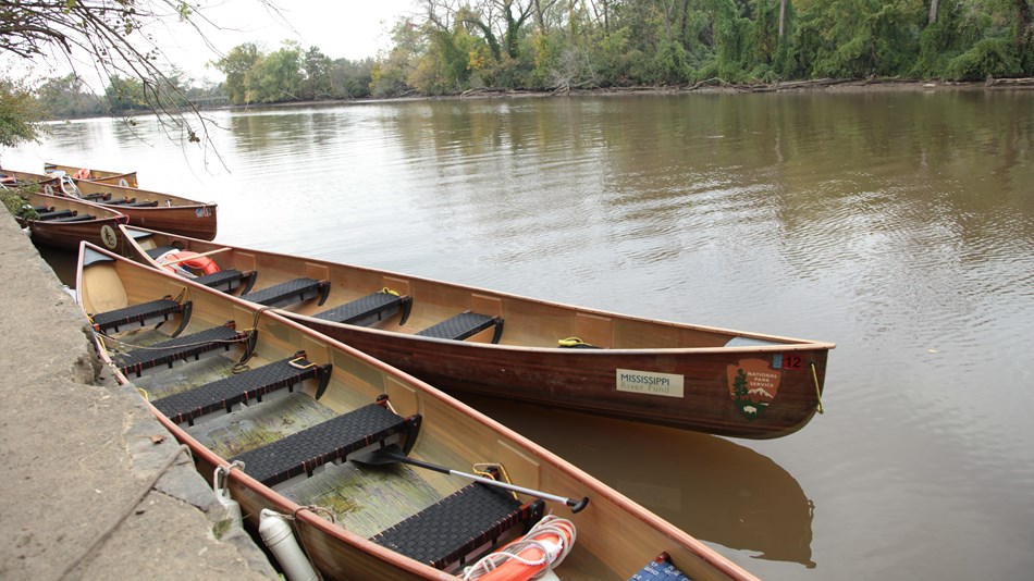 Canoes alongside a dock in a river