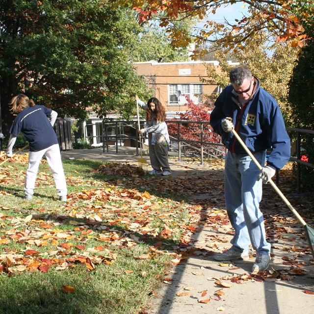 Volunteers raking leaves at Douglass home. 