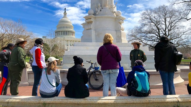 Park Rangers speaking to group of women in front of the Capitol Grounds