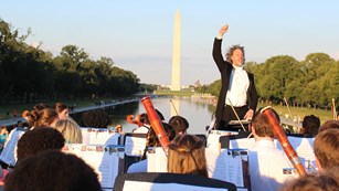 Orchestra plays next to the Reflecting Pool with the Washington Monument in the distance