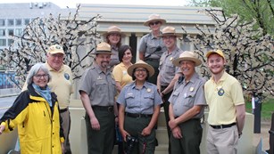 Park rangers and volunteers stand on a parade float decorated with a model of the Lincoln Memorial