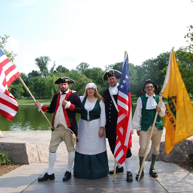 Revolutionary War Era reenactors holding period flags