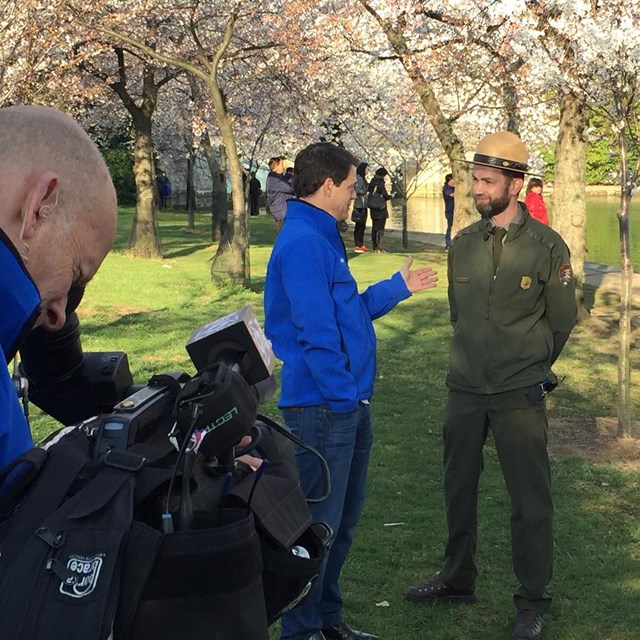 Ranger talking to a reporter in front of a camera