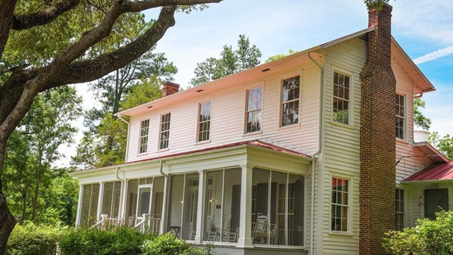 White two-story sided house with red roof