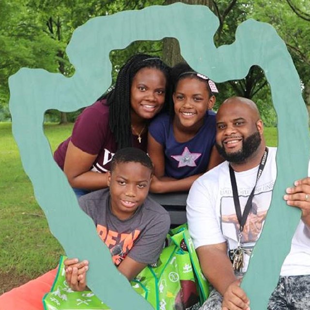 Family holding a cutout of the NPS arrowhead