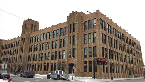 Monumental 4-story brick school building, taking up a city block, designed in Gothic Revival style