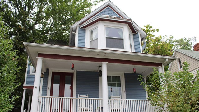 Two story blue building with large porch